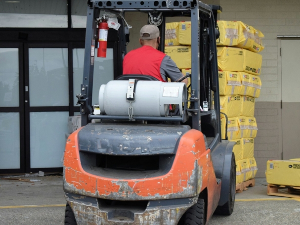 a man driving a forklift in a warehouse